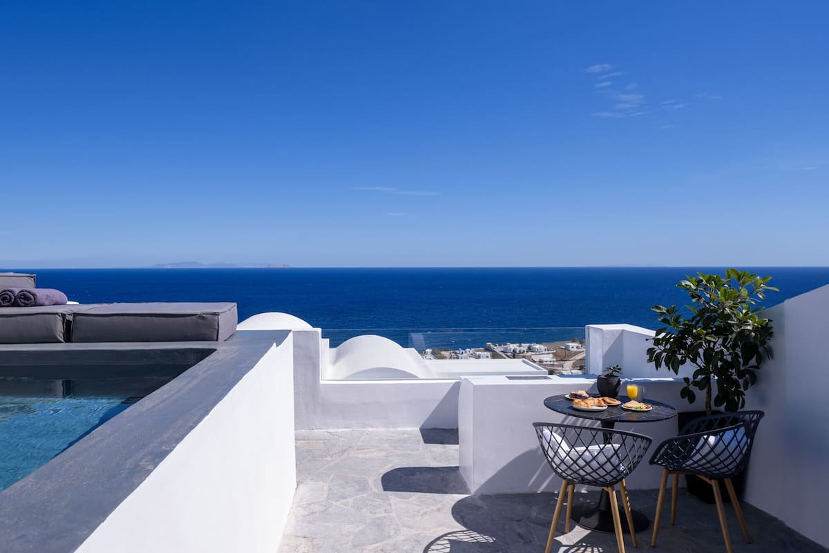 A rooftop terrace with a pool, seating area, and a table with chairs.