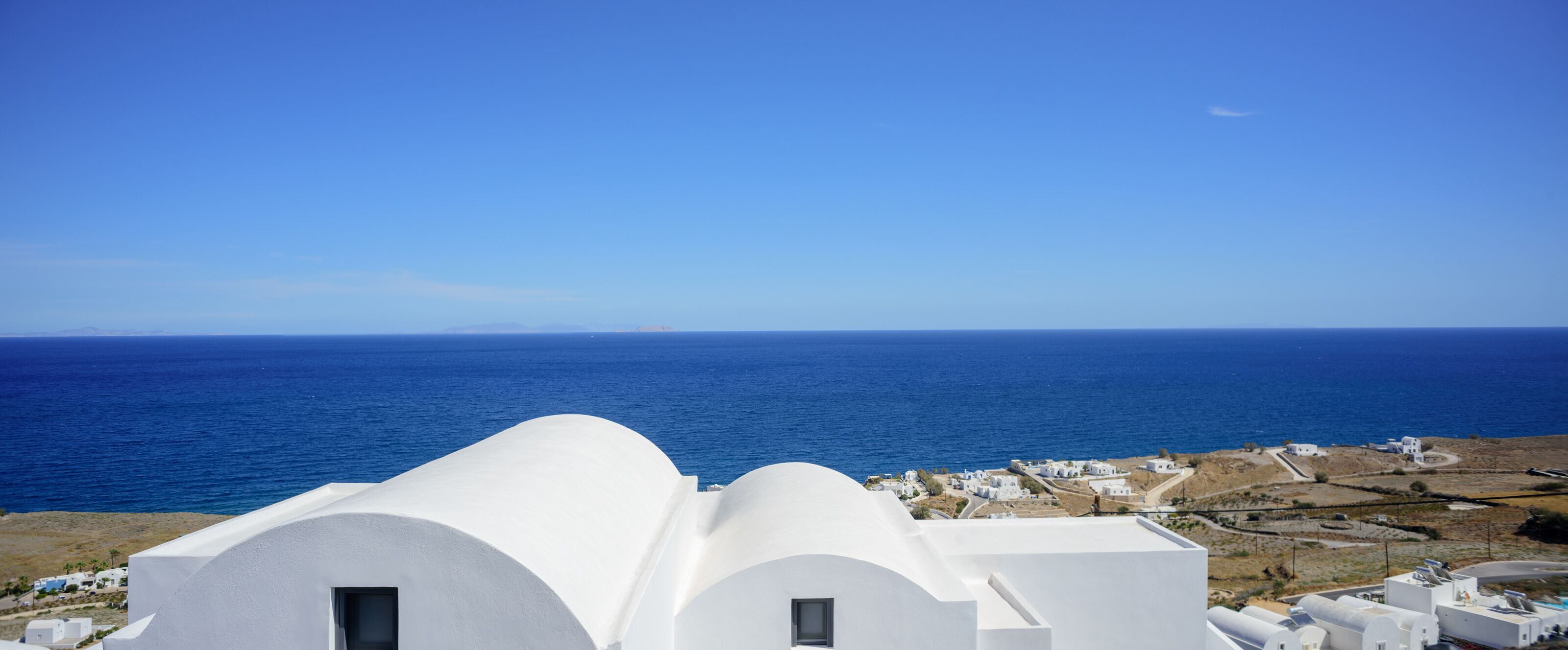 A coastal view with white buildings and the sea.