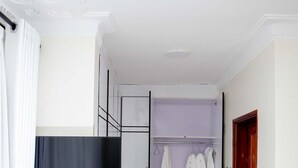 A hallway with a wardrobe, a television, and a door. - Stay.Plus Blueberry Villas Eldoret (Eldoret)