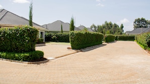 A residential street with houses, paved driveway, and well-maintained hedges. - Stay.Plus Blueberry Villas Eldoret (Eldoret)