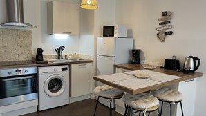 A compact kitchen with a washing machine, a coffee maker, and a toaster. - VANNES CENTER QUIET-COZY-T2 WITH PRIVATE PARKING-TERRACE-WIFI (Vannes)
