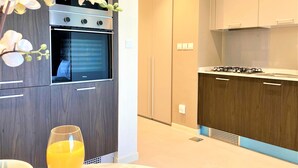 Une cuisine moderne avec des meubles de couleur bois foncé, un four encastré et une cuisinière à gaz.