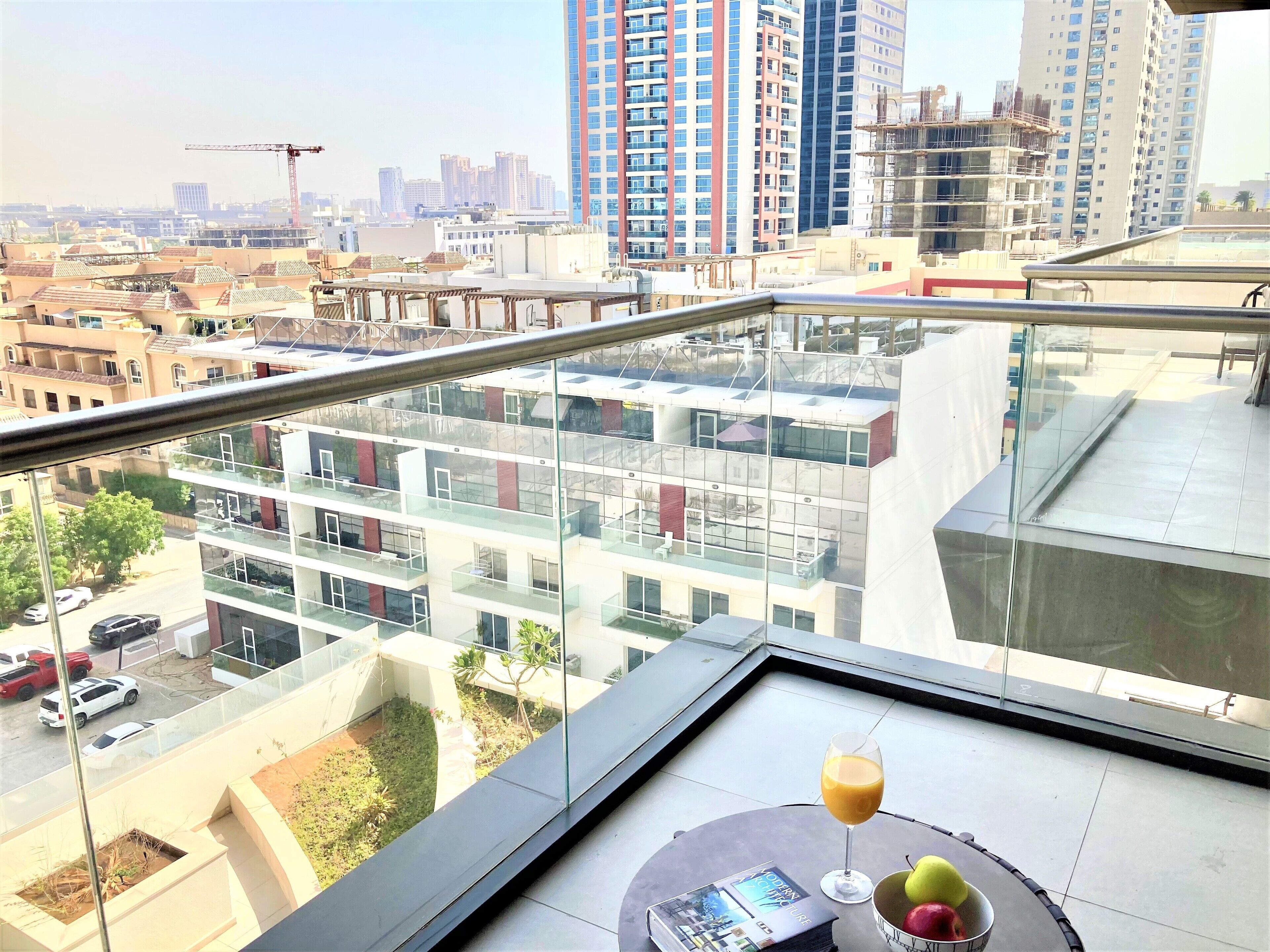 A modern apartment with a balcony overlooking a cityscape.