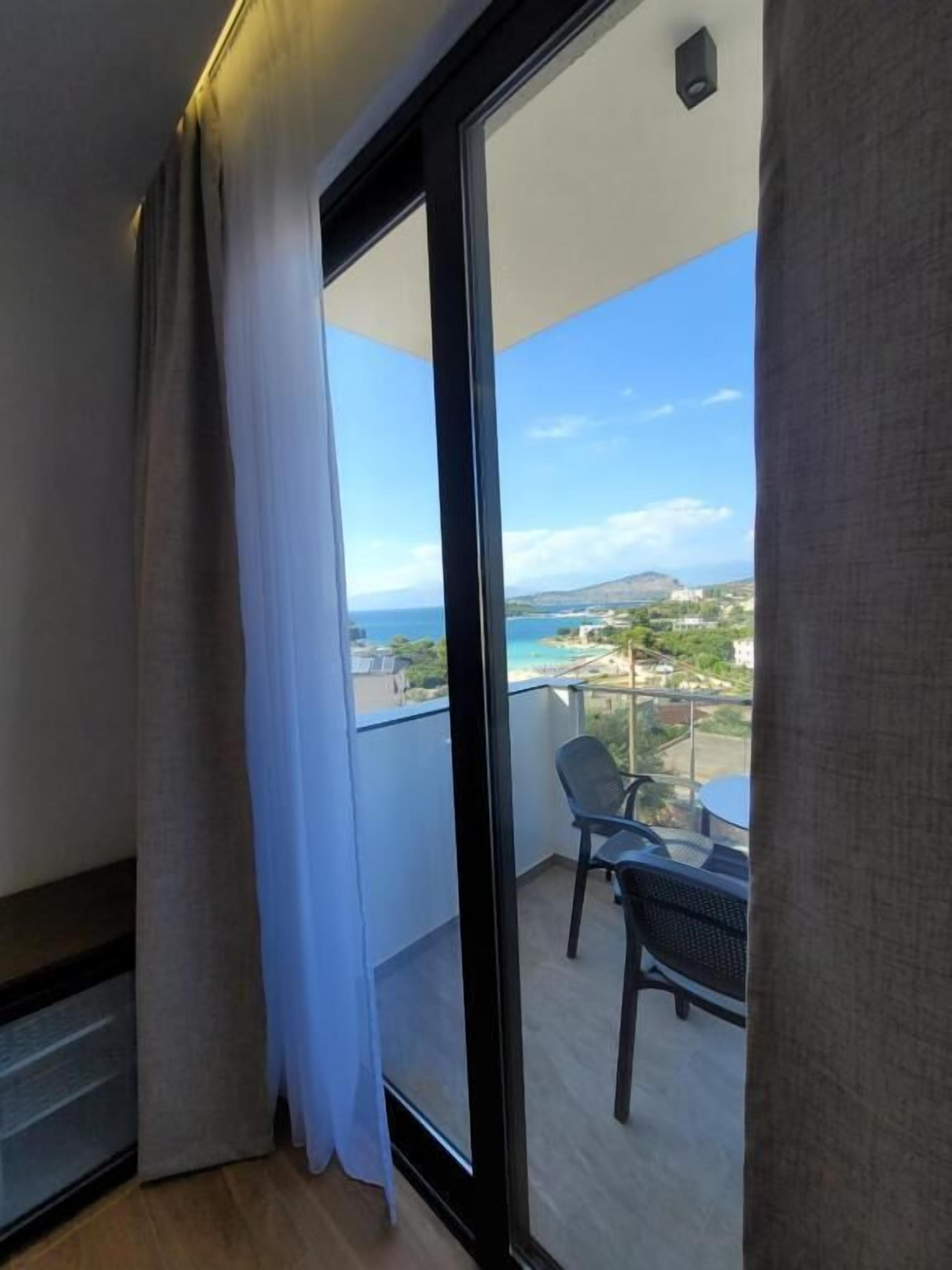 A balcony with a view of the sea and a chair.