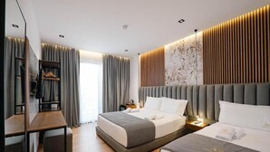 A modern hotel room with a large bed, a desk, and a wardrobe. - Siars Hotel (Ksamil)