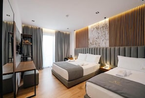 Una moderna camera d'hotel con un ampio letto, una scrivania e un armadio.