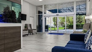 Zona de recepción con mostrador, asientos y vista al exterior.