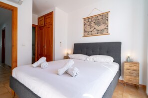 A hotel room with a large bed, wooden wardrobe, and a wall-mounted globe. - Azahara En Suite by Casasol (Nerja)
