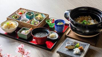 Een traditionele Japanse maaltijdopstelling met diverse gerechten en een grote zwarte pot.