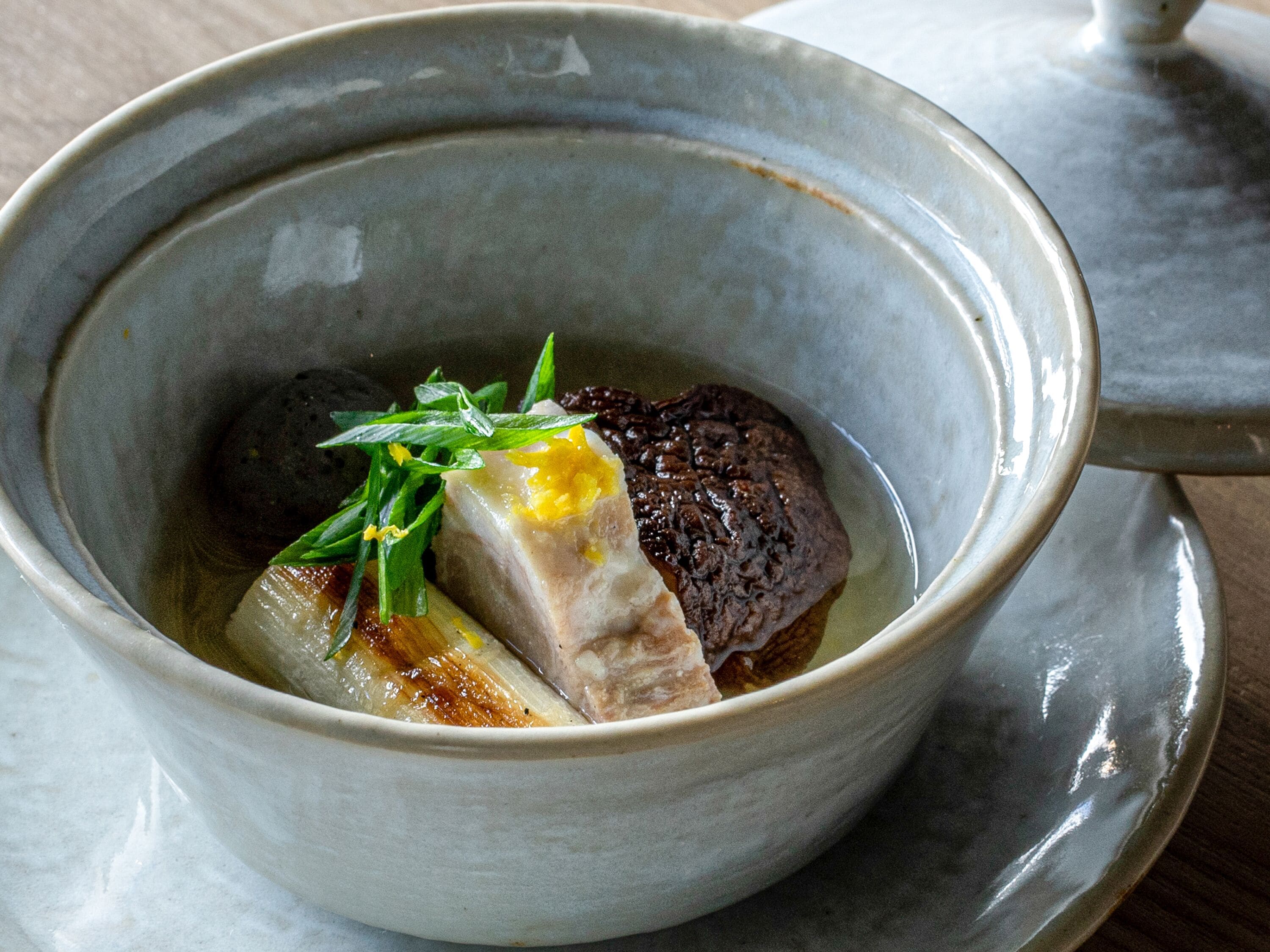 A bowl of food with a lid, placed on a table.