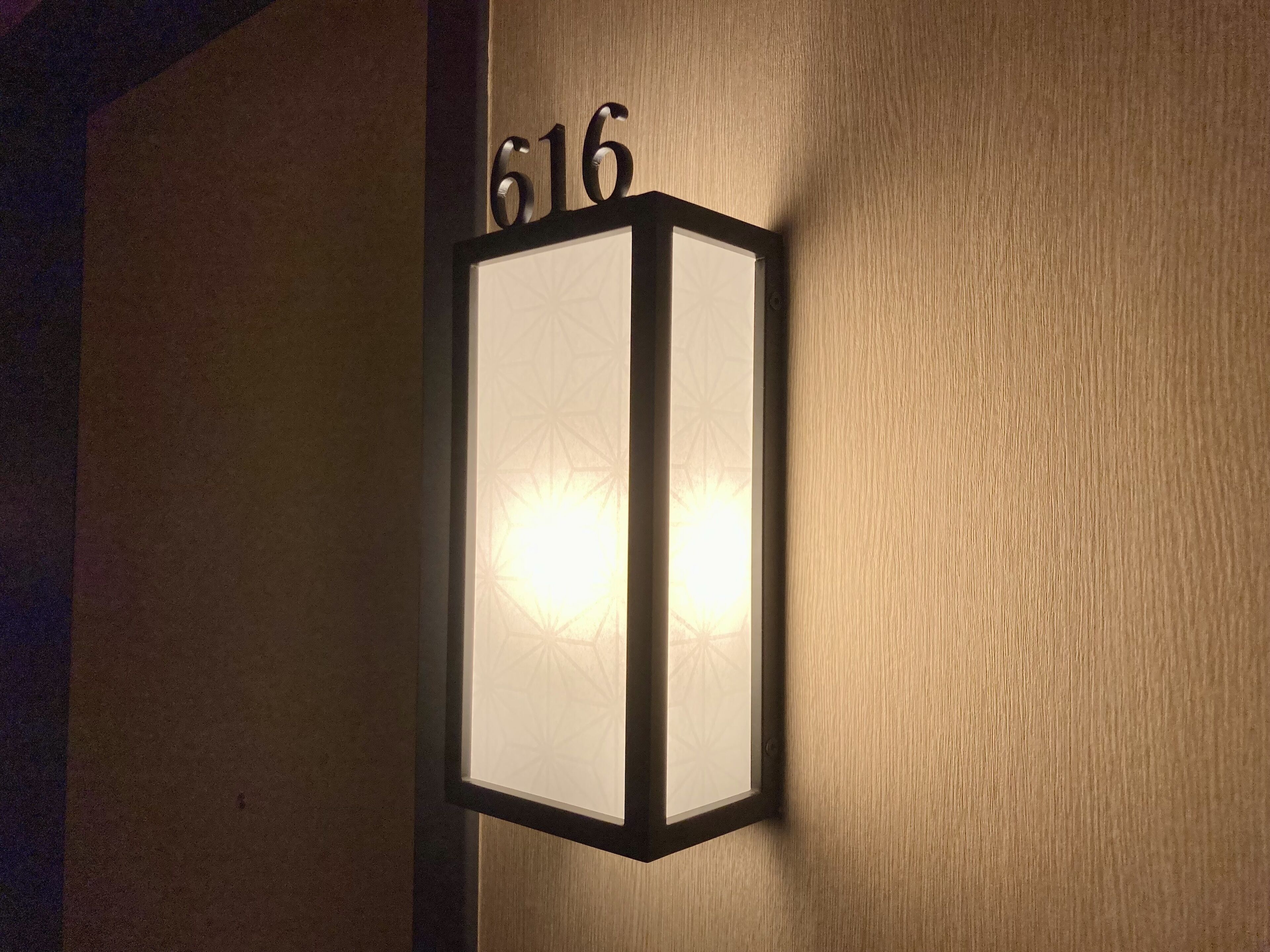 Een wandlamp met het nummer 616, dat een kamer of locatie aangeeft.