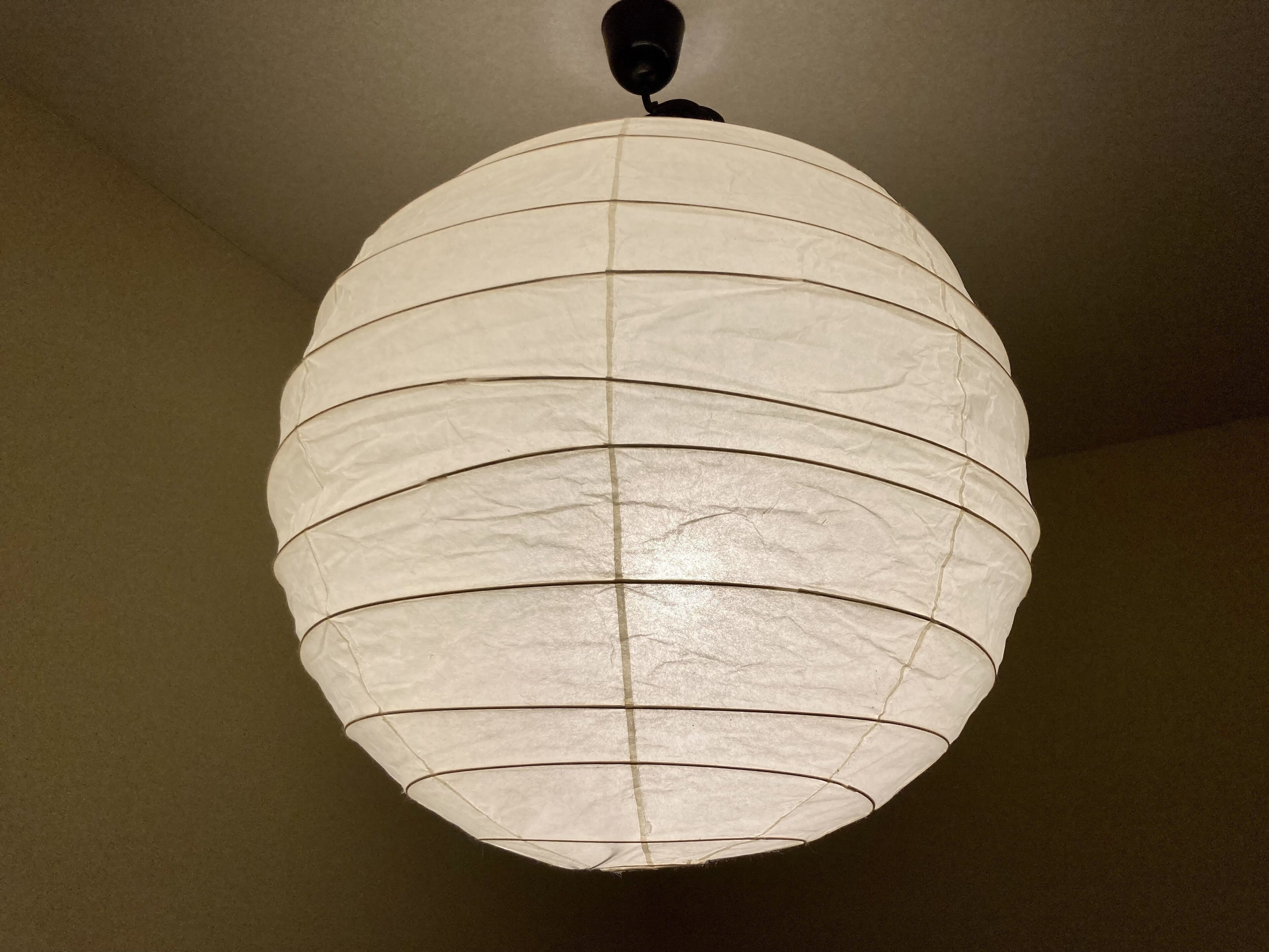 Un farol de papel esférico colgado del techo.