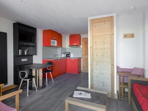 A compact living space with a kitchenette, a dining area, and a sleeping area.
