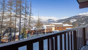 A mountain lodge with a wooden balcony overlooking a snowy landscape and snow-capped mountains. - Renovated Studio 2 pers · Wellness · Pets allowed (La Plagne Montchavin Les Coches)