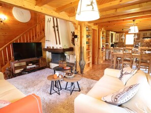 Een gezellig blokhut interieur met een open haard, houten meubels en een eethoek.