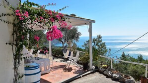 A terrace with a white pergola, white chairs, a table, and a large barrel. - - Gli Orizzonti di Agata - Villa with a wide view of the sea - MARGHERITA - (Puglia)