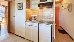 Uma cozinha compacta com micro-ondas, pia e forno embutido.