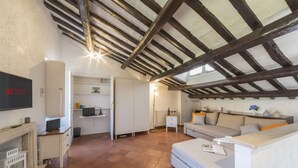 A cozy living room with a fireplace, a sofa, and a television labeled 'NETFLIX'. - [Trastevere] Cozy & Charme Apartment in Rome (Roma)