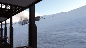 A snowy landscape with a wooden structure in the foreground.