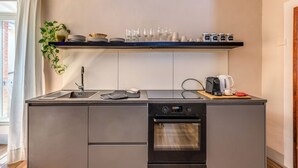 Una cuina moderna amb forn integrat, rentapelats i cafetera al taulell.