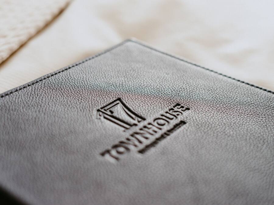 Un libro encuadernado en cuero con relieve que dice 'Townhouse' y 'Luxury Apartments'.