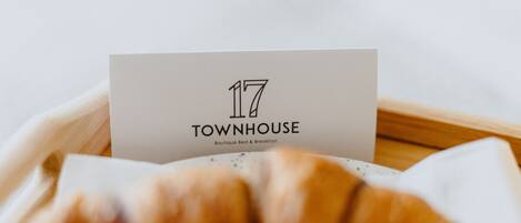 A business card for '17 Townhouse' with a focus on the card and a blurred croissant in the foreground.