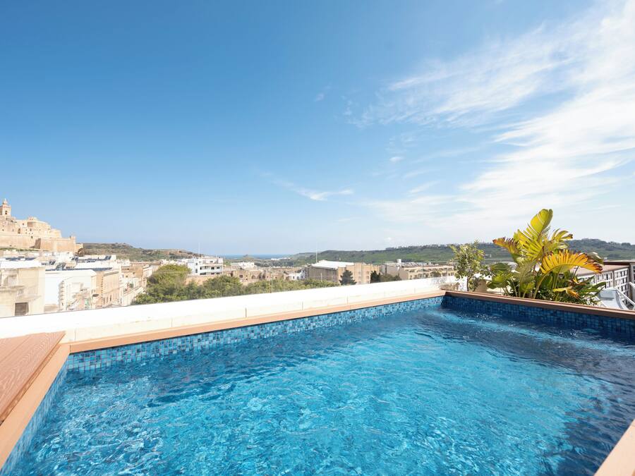 A rooftop pool with a clear view of the cityscape and distant hills.