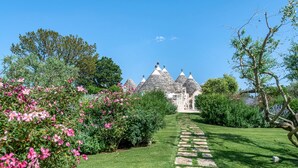 Un sentier de jardin menant à un bâtiment doté de plusieurs toits coniques.