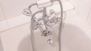 A bathtub with a handheld showerhead and a flexible hose. - Homely 1 Bedroom Apartment in Beckton With Parking (London)