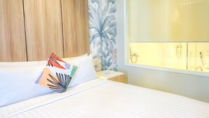 A hotel room with a bed, a nightstand, a window with a shower, and a wooden wardrobe. - Harolds Hotel Quezon City (Quezon City)