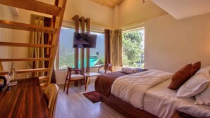 Un dormitorio con una cama grande, televisión, escritorio y silla.