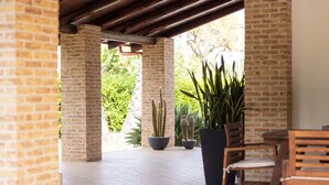 A patio area with brick pillars, a wooden bench, and potted cacti.
