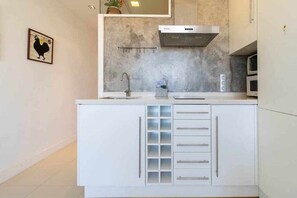 Eine moderne Küche mit Einbauherd, Spüle und Mikrowelle.