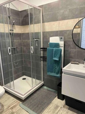 Regadera, secadora de cabello, toallas, papel de baño 