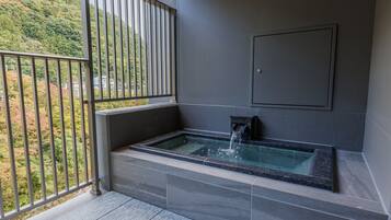 A spa area with a hot tub and a view of a mountainous landscape.