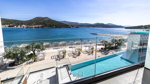 A balcony with a view of a beach and a swimming pool. - Marinus Beach Hotel (Marina)