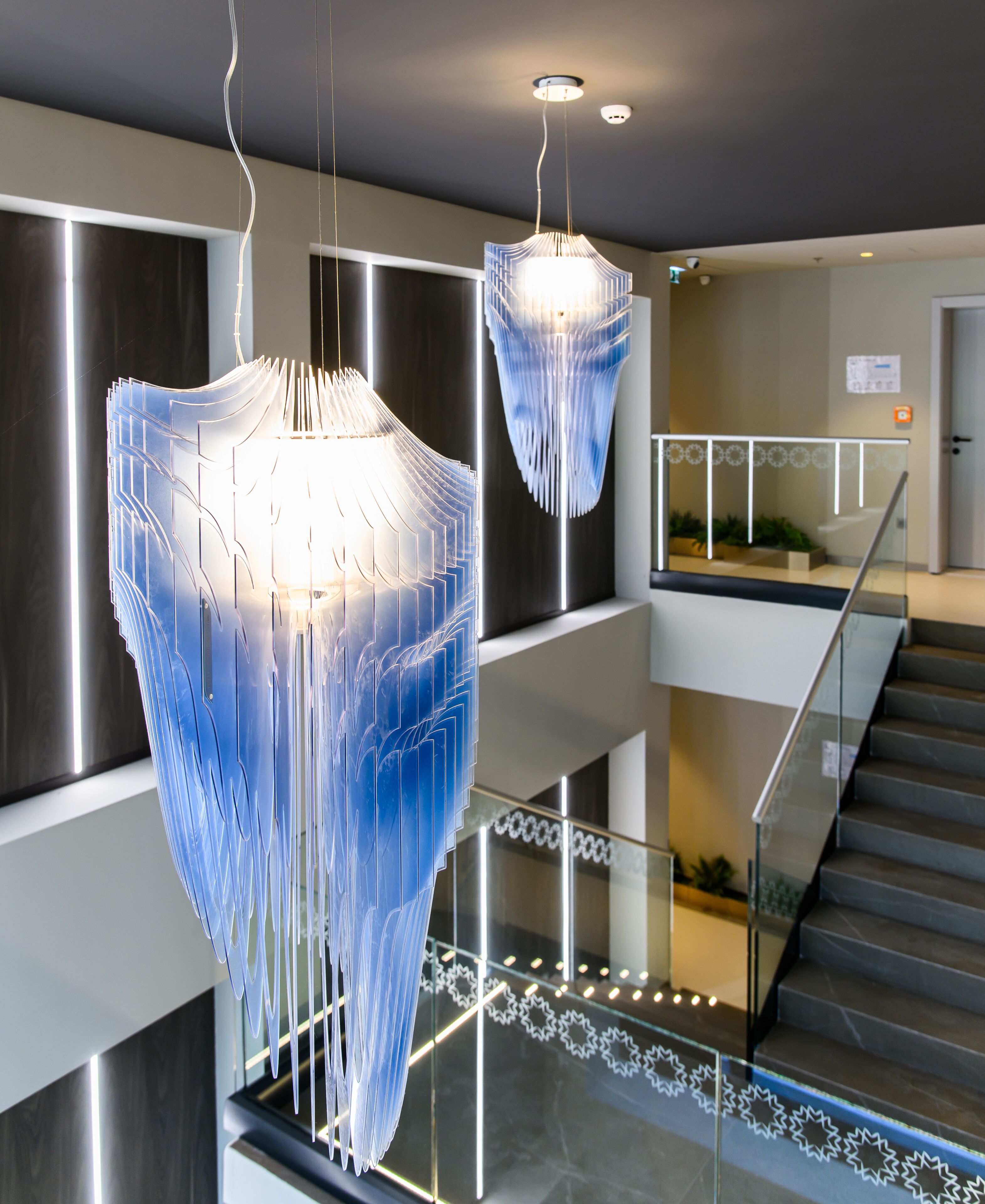 Ein modernes Interieur mit einer Treppe und zwei ungewöhnlichen Pendelleuchten.