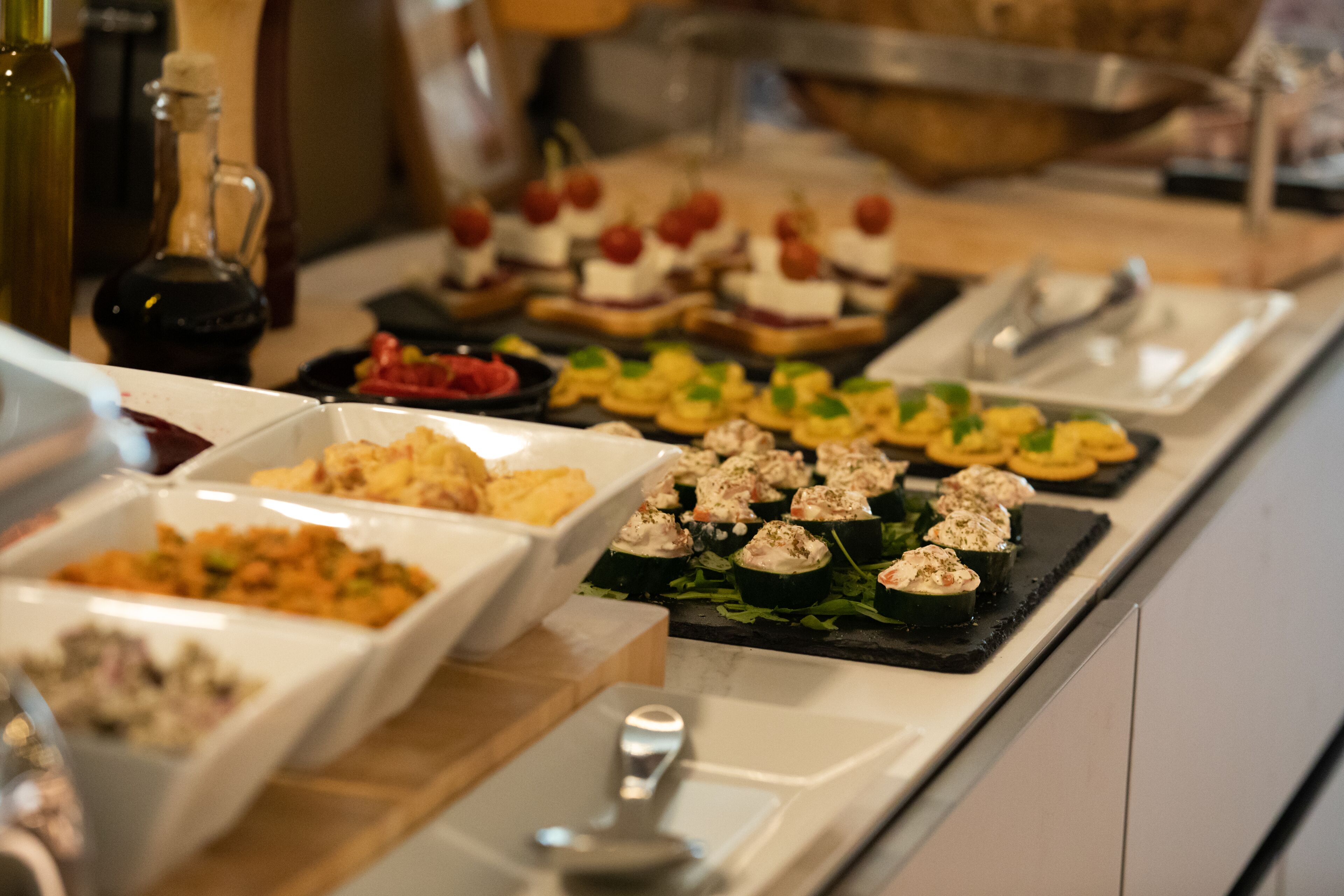 A buffet with various food items including salads, appetizers, and desserts.