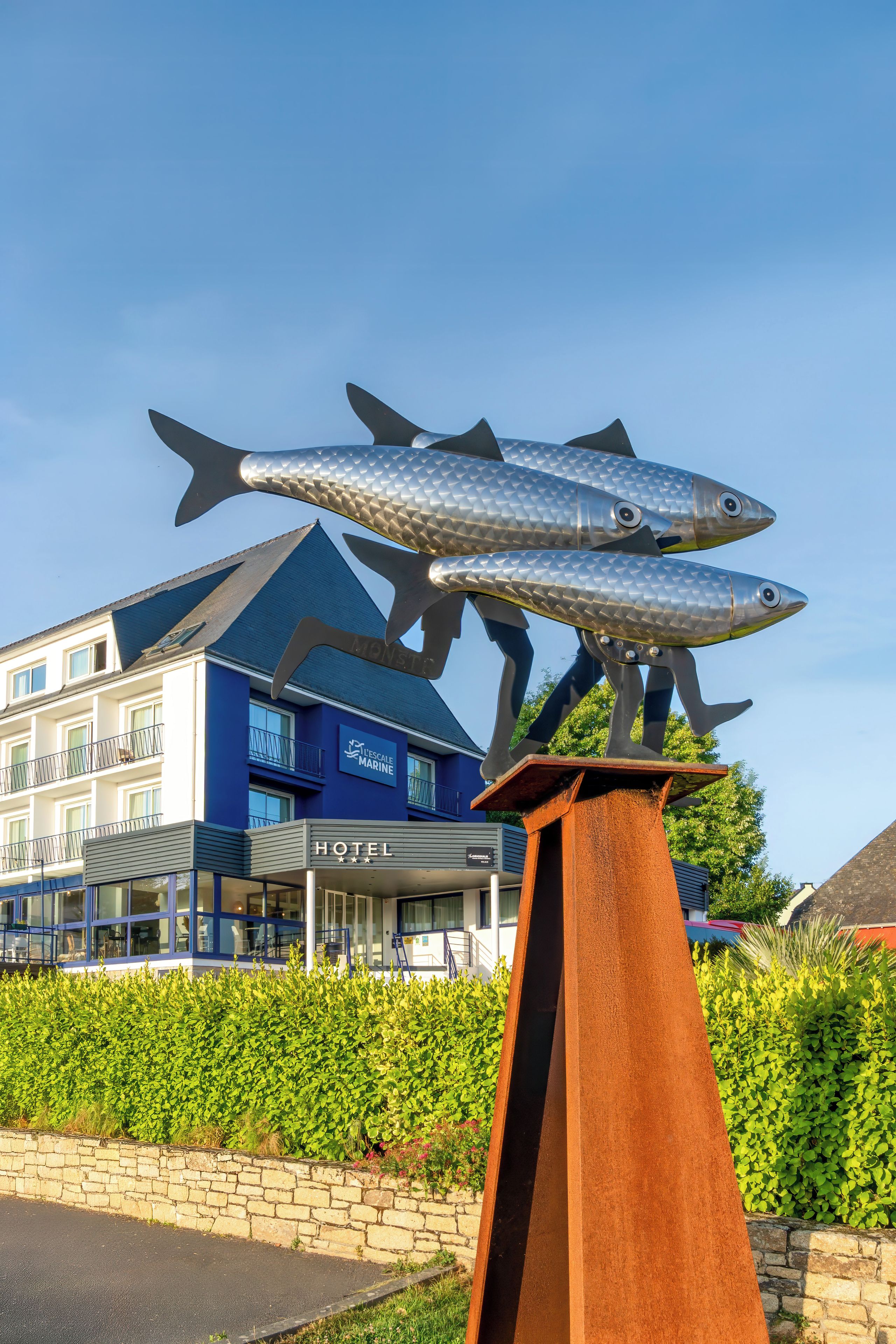 Een hotel met een blauwe gevel en een bord waarop 'HOTEL' staat.