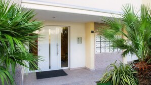 A hotel entrance with a glass door, a black mat, and a sign indicating room number 20.