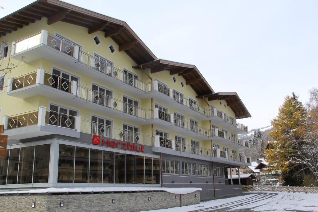A multi-story hotel with balconies and a sign reading "Herzblut."