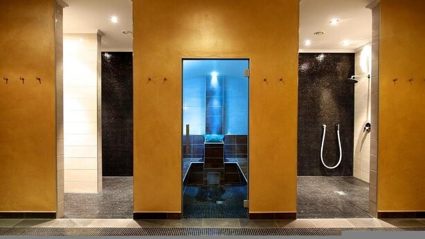 A modern bathroom with a central glass door, a shower area, and a tiled floor.