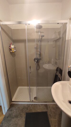 A glass-enclosed shower with a handheld showerhead and a handheld faucet. - Very close to Trastevere (Roma)