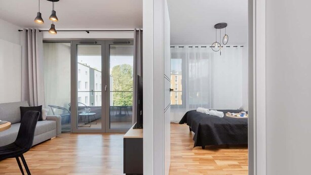 Un appartement moderne comprenant un espace de vie, un coin repas et une chambre.