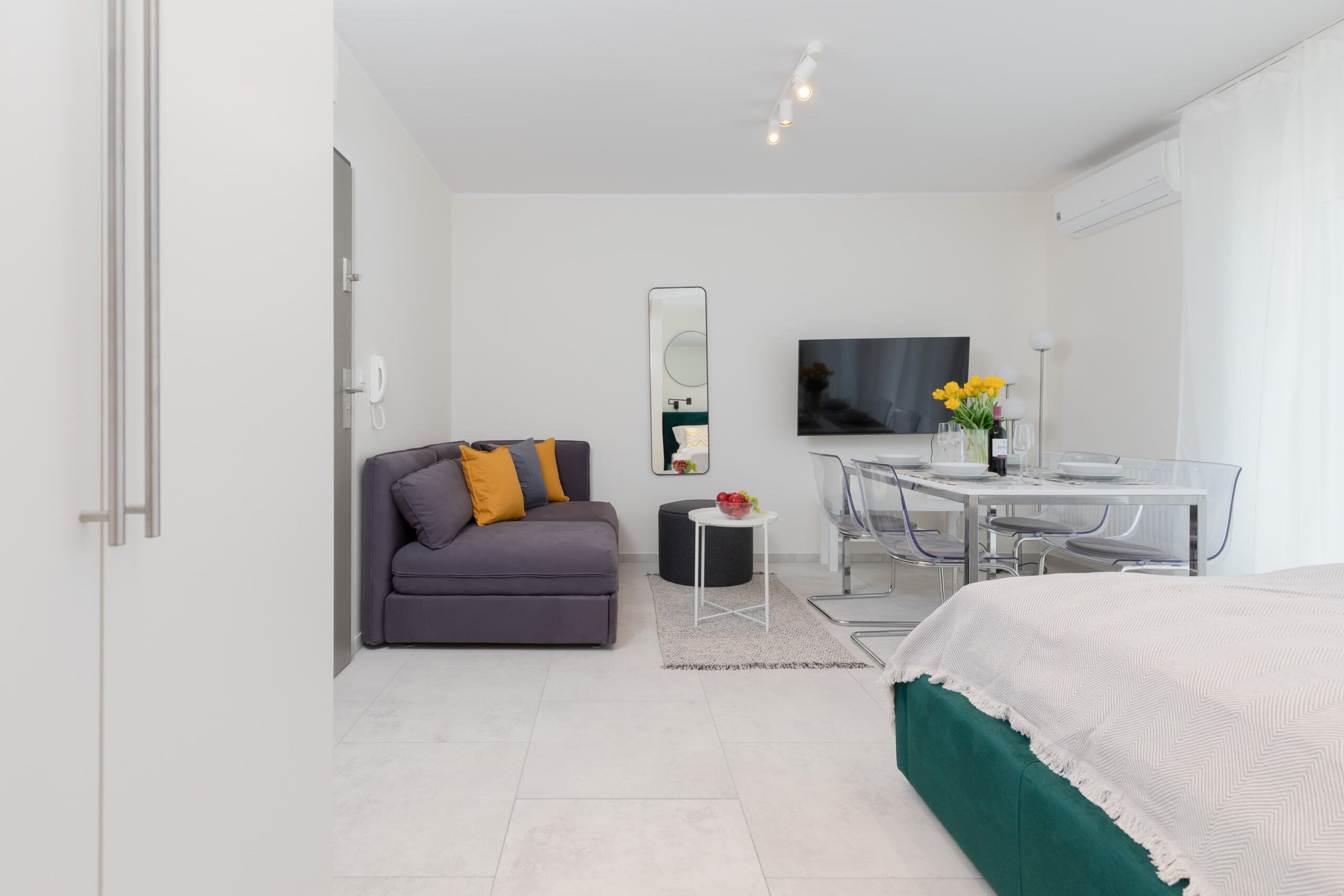 Une chambre d’hôtel moderne équipée d’un lit, d’un canapé, d’une table à manger et d’un téléviseur.