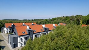 A residential area with modern houses featuring red-tiled roofs and grey exteriors.
