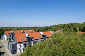 Ein Wohngebiet mit modernen Häusern, die rote Ziegeldächer und graue Fassaden haben.