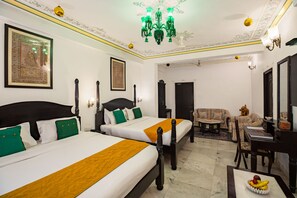 Une chambre d’hôtel avec deux lits, un coin repas et un coin salon.