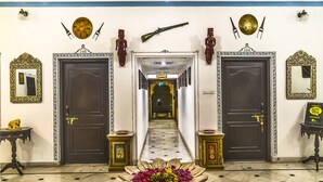 Un couloir avec deux portes, un arrangement floral et une pancarte sur laquelle on peut lire : « Inde, OUI ».