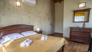 Ein Schlafzimmer mit einem hölzernen Bett, einem Nachttisch, einer Kommode und einem Spiegel.
